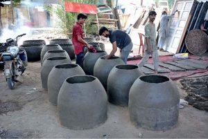 A worker is busy making and spreading tuff tiles for drying at his workplace