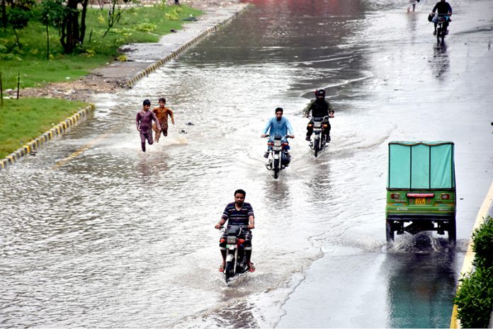 Vehicles passing through stagnant rainwater on a road after heavy rainfall in the Provincial Capital 