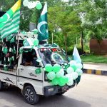 A Suzuki van decorated with national flags and balloons moves along a cool road, spreading patriotic spirit ahead of the 78th Independence Day celebrations.