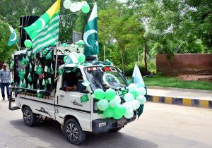 A Suzuki van decorated with national flags and balloons moves along a cool road, spreading patriotic spirit ahead of the 78th Independence Day celebrations.