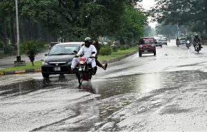 A vehicle passing through rain water accumulated on road after rain in the federal capital