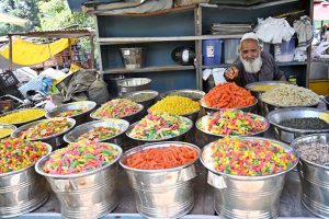A family purchasing toys from an elderly vendor’s stall at I-9/4 bazaar in the Federal Capital.