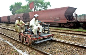 Railway engineering staff travel on a maintenance rail cart along the track during repair work at Cantt Station.