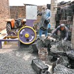 Labourers busy in crushing plastic fruit boxes for recycling process at Phandu area