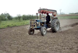 A farmer busy preparing land for next crop with help of tractor at Lahore Road
