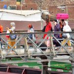 Railway porters carrying passengers' luggage on a bridge at the Railway Station.
