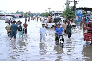 Motorcyclists are wades through floodwaters at Jail Road after heavy rainfall in the city