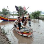 Youngsters enjoying boat ride at the bank of River Chenab