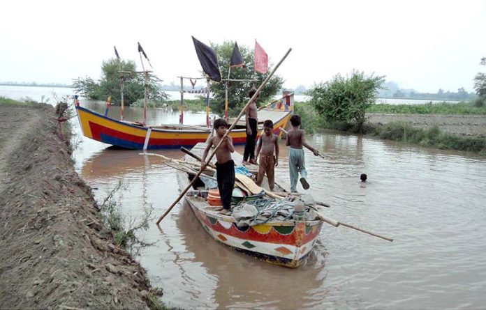 Youngsters enjoying boat ride at the bank of River Chenab