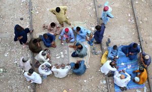 People playing cards to spend their time on railway tracks near Railway Station.