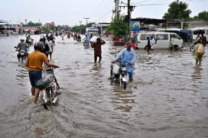 A large number of people are passing through floodwaters at Jail Road after heavy rainfall in the city