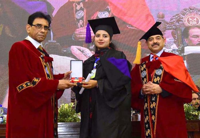 Federal Minister for Education and Professional Training, Dr. Khalid Maqbool Siddiqui, awards a medal to a high-achieving student during the 25th Convocation of NUML