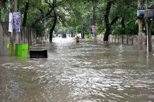 A large number of people are passing through floodwaters at Jail Road after heavy rainfall in the city