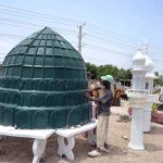 A worker is busy putting the final touches on the mosque’s green dome and minaret at Eidgah Road