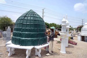 A worker is busy putting the final touches on the mosque’s green dome and minaret at Eidgah Road