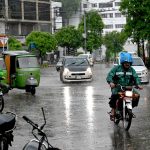 Vehicles make their way during the rain in the provincial capital