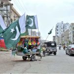 A vendor displaying national flags and another items at Gulshan-e-Sajjad Road to attract the customers in connection with upcoming 78th Independence Day celebration of Pakistan