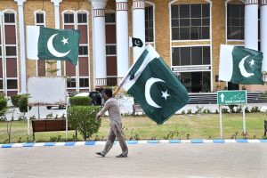 A staff member hoists the national flag at International Medical and Technical College Thatta during Jashan-e-Marka-e-Haq and Independence Day celebrations ahead of Pakistan’s 78th Independence Day.