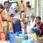 Residents of Korangi area getting water from a hand-pump as the city faces water shortage 