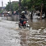 A motorcyclist wades through accumulated rainwater on Makka Road after heavy showers lashed the provincial capital.