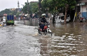 A motorcyclist wades through accumulated rainwater on Makka Road after heavy showers lashed the provincial capital.