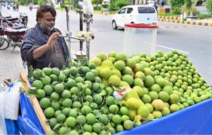 A vendor busy in extracting sweet lime and grapefruit juice at Stadium Road