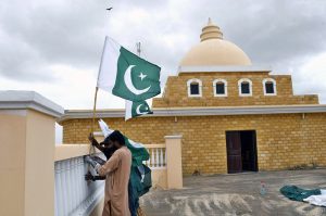 A staff member hoists the national flag at International Medical and Technical College Thatta during Jashan-e-Marka-e-Haq and Independence Day celebrations ahead of Pakistan’s 78th Independence Day.
