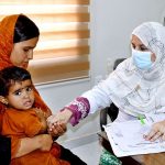 A doctor examines a patient during a free medical camp for expectant mothers and children, held in connection with Independence Day celebrations at LUMHS, Jamshoro.