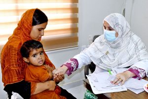 A doctor examines a patient during a free medical camp for expectant mothers and children, held in connection with Independence Day celebrations at LUMHS, Jamshoro.