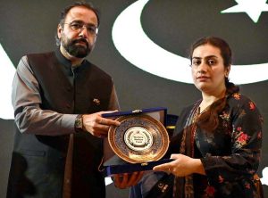 Federal Minister for Overseas Pakistanis and Human Resource Development, Chaudhry Salik Hussain, awarding a shield to young female achiever during the Marka-e-Haq and 78th Independence Day celebrations organized by the Workers Welfare Fund at the National Library Auditorium