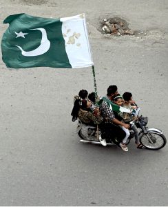 Youngsters having costumes in the colors of national flag of Pakistan skating on the roads to celebrate the 78th Independence Day of Pakistan in the city