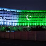 An illuminated view of Wapda House building adorned with Pakistani flag lights in connection with Independence Day celebrations