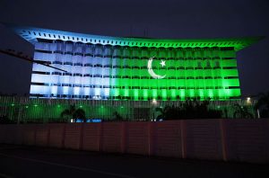 An illuminated view of Wapda House building adorned with Pakistani flag lights in connection with Independence Day celebrations