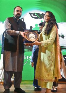 Federal Minister for Overseas Pakistanis and Human Resource Development, Chaudhry Salik Hussain, awarding a shield to young female achiever during the Marka-e-Haq and 78th Independence Day celebrations organized by the Workers Welfare Fund at the National Library Auditorium