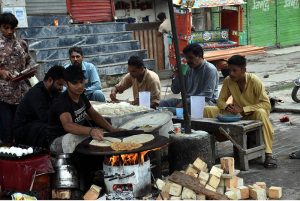 A street vendor prepares and sells traditional fresh laddoo on his handcart
