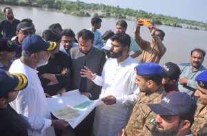 Commissioner Aamir Karim Khan and Deputy Commissioner Wasim Hamid Sindhu being briefed and issuing directions on safety measures during their visit to review the flood situation near River Chenab at Head Muhammad Wala.