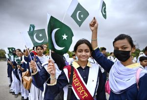 Private school students wave national flags during their visit to Mazar-e- Quaid in connection with Independence Day & ‘Maarka-e-Haq’ celebrations.