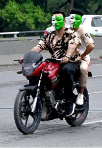 Youngsters having costumes in the colors of national flag of Pakistan skating on the roads to celebrate the 78th Independence Day of Pakistan in the city