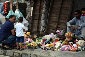 A vendor displays toys along the roadside to attract customers in the city