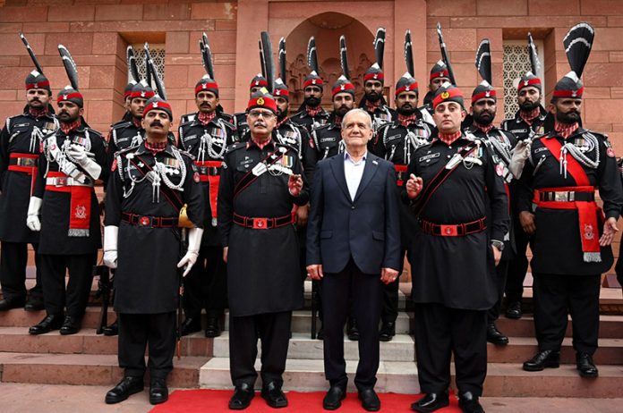 Iran's President Dr. Masoud Pezeshkian poses for a group photograph with Rangers after paying floral tribute at Mazar-e-Iqbal to honor Allama Dr. Muhammad Iqbal, the 'Poet of the East
