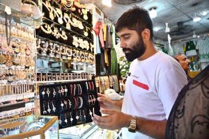 A vendor is arranging artificial jewelry on his setup to attract the customer,as rising gold prices drive demand for budget-friendly options