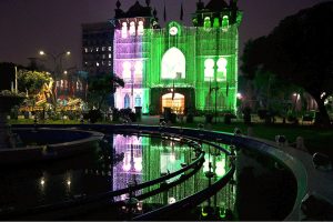 An illuminated view of Wapda House building adorned with Pakistani flag lights in connection with Independence Day celebrations