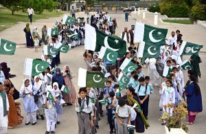 Private school students wave national flags during their visit to Mazar-e- Quaid in connection with Independence Day & ‘Maarka-e-Haq’ celebrations.