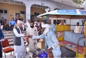 Federal Minister for Board of investment, Qaiser Ahmad Sheikh, distributing 5 liter free petrol slips to the motorcycle rickshaw drivers during the celebration of Independence Day celebrations.