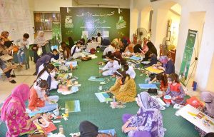 Art students paint their ideas on canvas during a painting competition organized by the Punjab Council of Arts, Faisalabad Division, to mark Independence Day and Marka-e-Haq