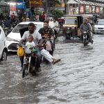 Commuters wade through stagnant rainwater at Lucky Star. The accumulation of water causes severe inconvenience for motorists and pedestrians