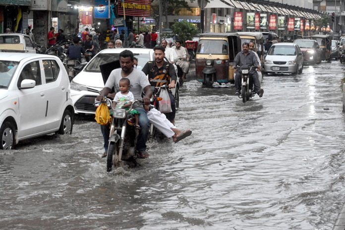 Commuters wade through stagnant rainwater at Lucky Star. The accumulation of water causes severe inconvenience for motorists and pedestrians