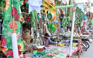 A vendor displaying flags and badges at a roadside stall in connection with Rabi-ul-Awal Celebrations