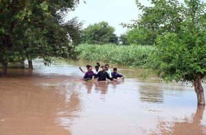 Residents wade through floodwater while evacuating to safer places after Mid Ranjha was inundated, as rivers swelled above dangerous levels due to heavy rains and the opening of Indian floodgates.