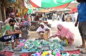 Women buying for Independence Day items from a roadside stall in Urdu Bazaar in connection with the upcoming Independence Day.